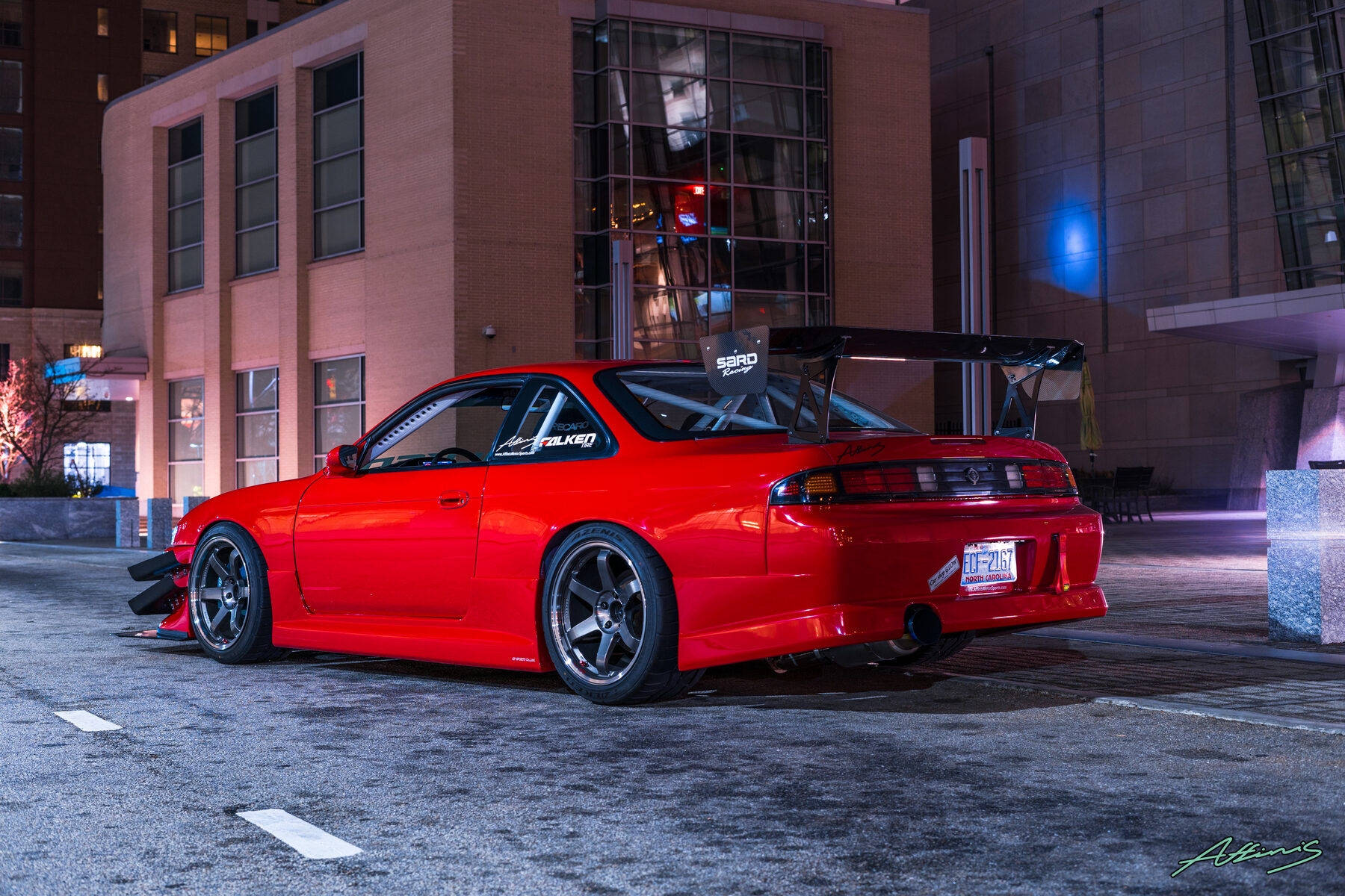 A tuned car under city lights at night